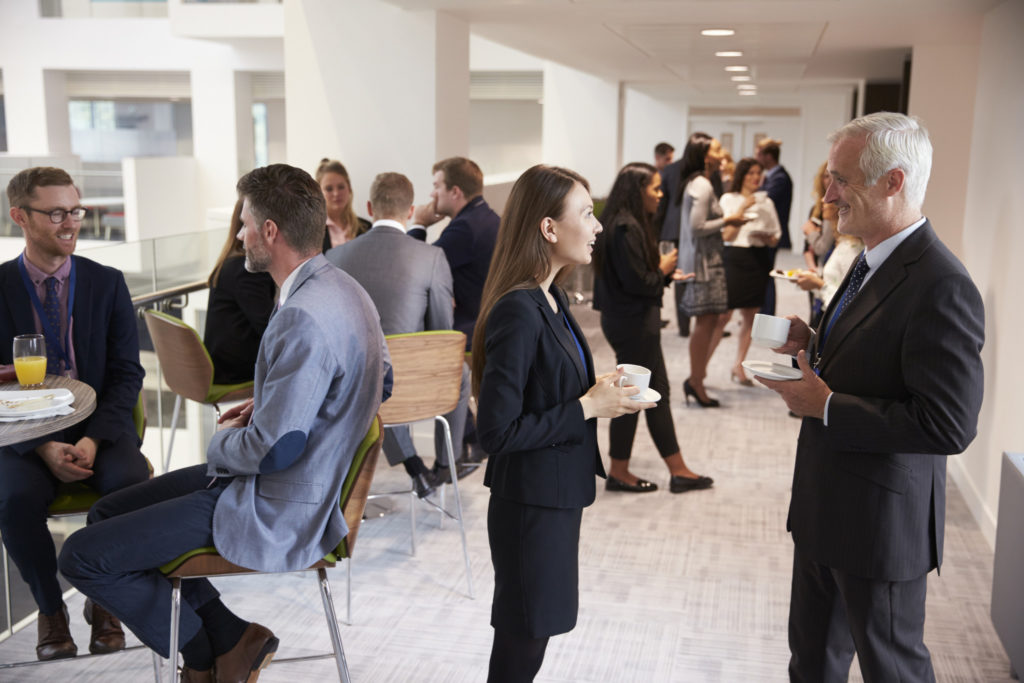  A group of diverse business professionals networking in a modern office space.